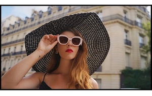 Occhiali da sole rosa con montatura spessa e grande cappello di paglia nero da donna
