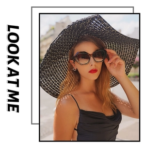 Dettaglio modella con cappello di paglia nero e occhiali da sole geometrici tartarugati