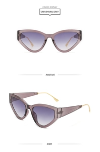 Détail de lunettes de soleil œil-de-chat avec monture grise et branches en métal doré