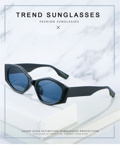 Detailed view of black rectangular sunglasses with UV400 lenses on white marble stand