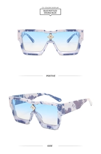 Detail view of blue mottled square sunglasses with gradient lenses and crystal bridge