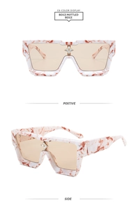 Detail of beige mottled oversized sunglasses featuring a floral metal bridge accent
