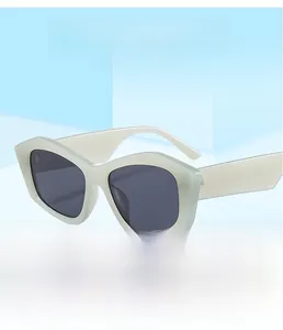 Detail of square geometric sunglasses with thick light gray frames and dark tinted lenses