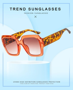 Gros plan sur lunettes orange translucides avec protection UV400 et branches en écaille