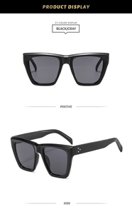 Détail des lunettes de soleil carrées noires avec rivets et verres teintés gris