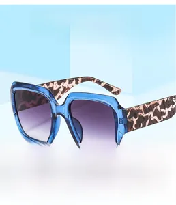 Détail de lunettes de soleil carrées bleu transparent avec branches écaille et verres dégradés