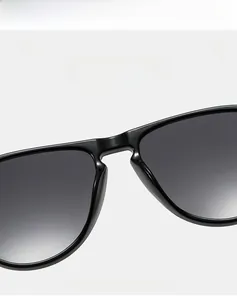 Macro detail of glossy black sunglasses featuring integrated nose pads and sleek frame joints