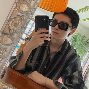 Fashionable square black sunglasses for women in a stylish mirror selfie indoor setting