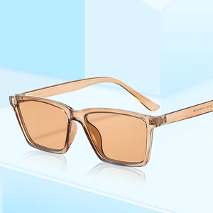 Fashionable square amber resin sunglasses with light orange lenses on blue geometric blocks