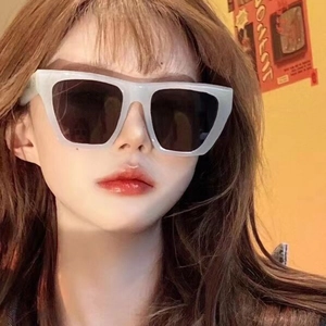 Lunettes de soleil carrées à texture marbre et verres foncés portées par un mannequin