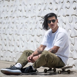 Men's outdoor style featuring a white crewneck T-shirt and olive cargo pants with sneakers