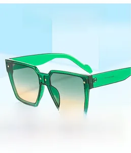 Détail macro de grandes lunettes de soleil dégradées vert avec des rivets ronds