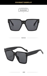 Détail de lunettes de soleil carrées noires avec verres gris et rivets dorés