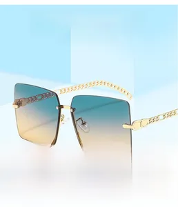 Detail of square oversized sunglasses with blue-yellow gradient lenses and chain metal arms