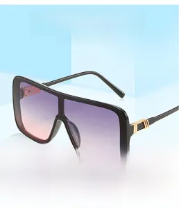 Detail of square oversized sunglasses showing golden metal accents and gradient lenses