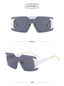 Detail view of white frame oversized sunglasses with gold metal temples and grey lenses