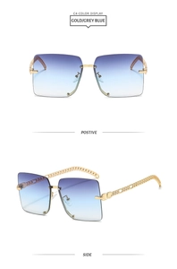 Detail view of gold chain temple and grey blue gradient lens on rimless sunglasses