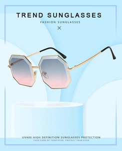 Detailed view of oversized octagonal sunglasses with gradient blue-pink lenses and gold metal frame