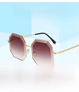 Detail of octagonal metal sunglasses with gradient pink lenses on a blue stand
