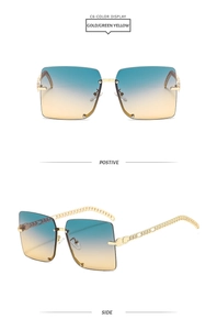 Detail of square rimless sunglasses with gold chain temples and blue-yellow gradient lens