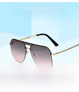 Detail of aviator sunglasses with gold metal frame and grey to pink gradient lenses