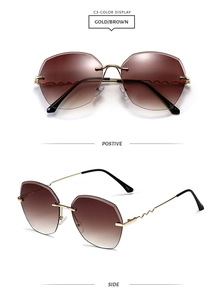 Detail view of gold metal sunglasses with wavy temples and brown gradient lenses