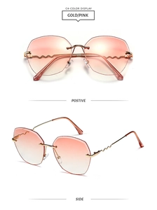 Detail of rimless gold sunglasses with pink gradient lenses and wavy metal temples