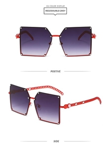 Dettaglio occhiali da sole rossi senza montatura con stanghette a catena e lenti viola sfumate