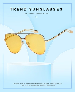 Detail of yellow aviator sunglasses with gold double bridge metal frame and UV400 lenses