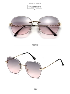 Close-up of irregular rimless sunglasses with gold wavy temples and grey-pink lenses