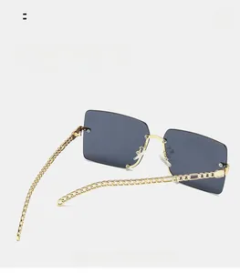 Detail of square oversized sunglasses with gold chain temples and gray-blue lenses