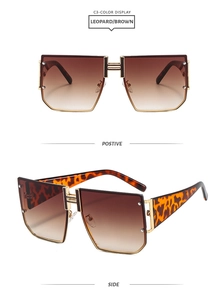 Close-up of leopard print sunglasses with H-shaped gold metal bridge and brown gradient lenses