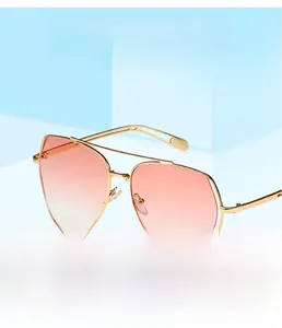 Detail of oversized irregular metal frame sunglasses with gradient orange and pink lenses