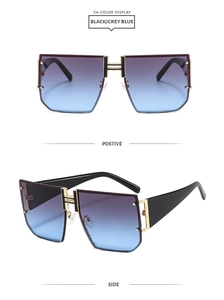 Close-up of black sunglasses with blue gradient lenses and golden H-shaped metal bridge