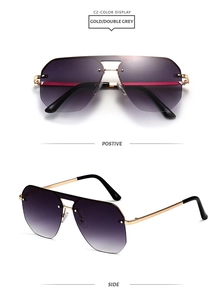Close-up of double-beam oversized sunglasses with gold frames and gradient grey lenses