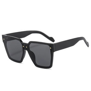 Lunettes de soleil carrées noires avec rivets dorés, vue élégante sous un angle de 45 degrés
