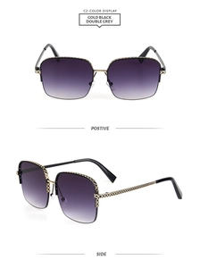 Detail of gold metal frame sunglasses with textured temples and grey gradient lenses