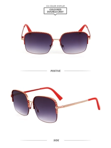 Detailed view of gold metal oversized sunglasses with red temples and grey gradient lenses