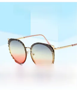Detail view of cat-ear gold frame sunglasses with scalloped edges and gradient lenses