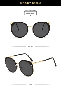 Detail view of cat ear sunglasses with gold frame and wavy gray faceted lenses