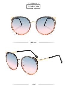 Close-up of gold cat-eye sunglasses featuring blue-pink gradient lenses and wavy edge detail