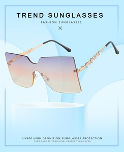 Close-up of rimless gradient sunglasses with gold metal temples and rhinestone detailing
