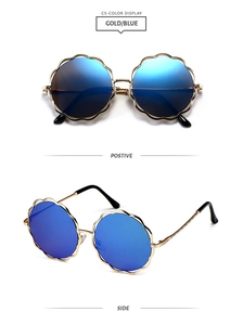 Détail des lunettes de soleil dorées en forme de fleur avec des verres miroir bleus