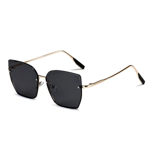 Lunettes de soleil œil-de-chat géométriques modernes avec monture dorée et verres gris foncé