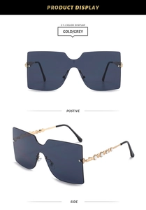Detail of rimless oversized sunglasses with gold rhinestone temples and grey lenses
