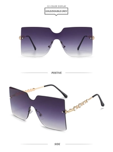 Detailed view of oversized rimless sunglasses with purple gradient lenses and rhinestone temples