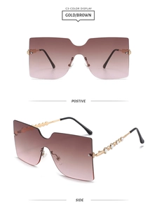 Detail of rimless shield sunglasses with rhinestone temples and gradient brown lenses