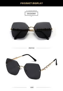 Detail of gray rimless sunglasses with gold wavy temples and sparkling rhinestone inlay