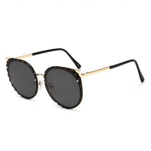 Cat eye sunglasses with golden frame and black round lenses in a vintage retro style