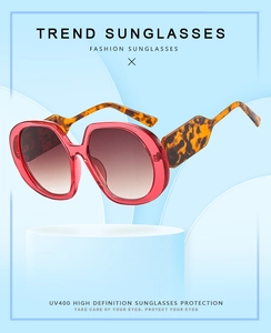 Detail of UV400 oversized sunglasses with red frames and tortoise shell temples